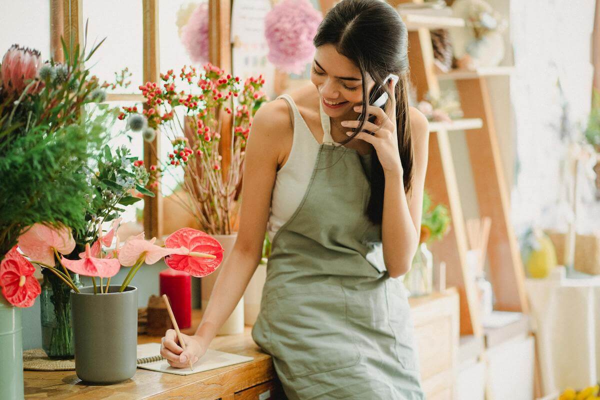 Happy Marin florist taking a phone order, representing success with Marin Google Maps Marketing.