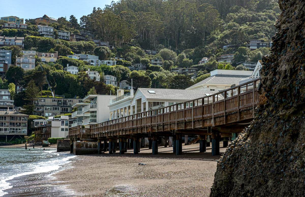 Sausalito beach with dock and hillside homes in Marin County.