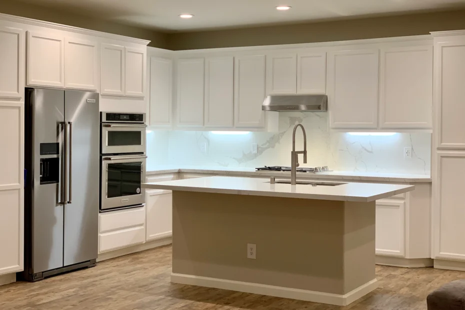 Remodeled kitchen with white cabinets, stainless steel appliances, and marble countertops by Terranova Construction.