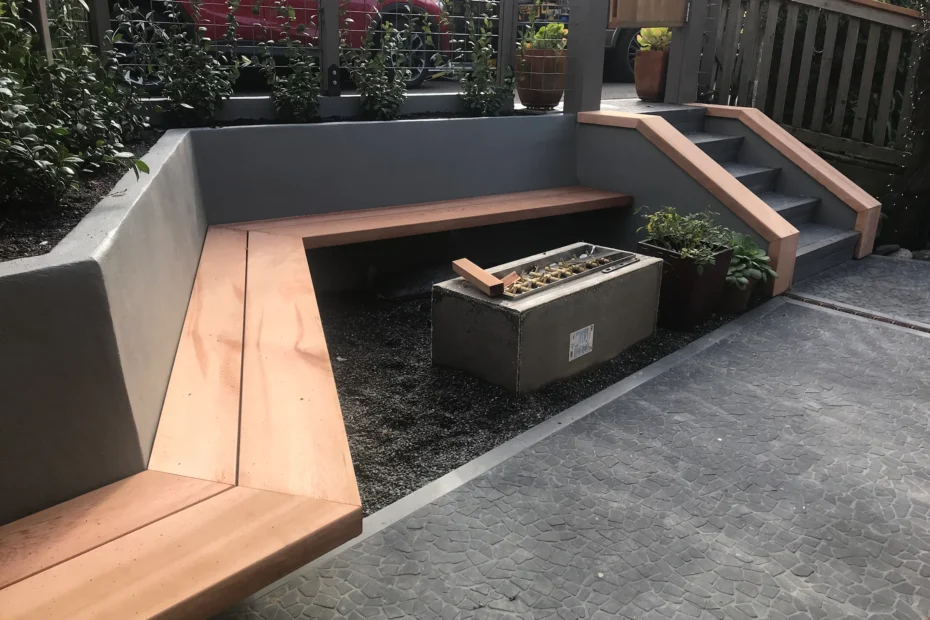 Outdoor seating area with concrete backs, wood benches, fire pit, and stone-textured patio built by WEH General Builders.