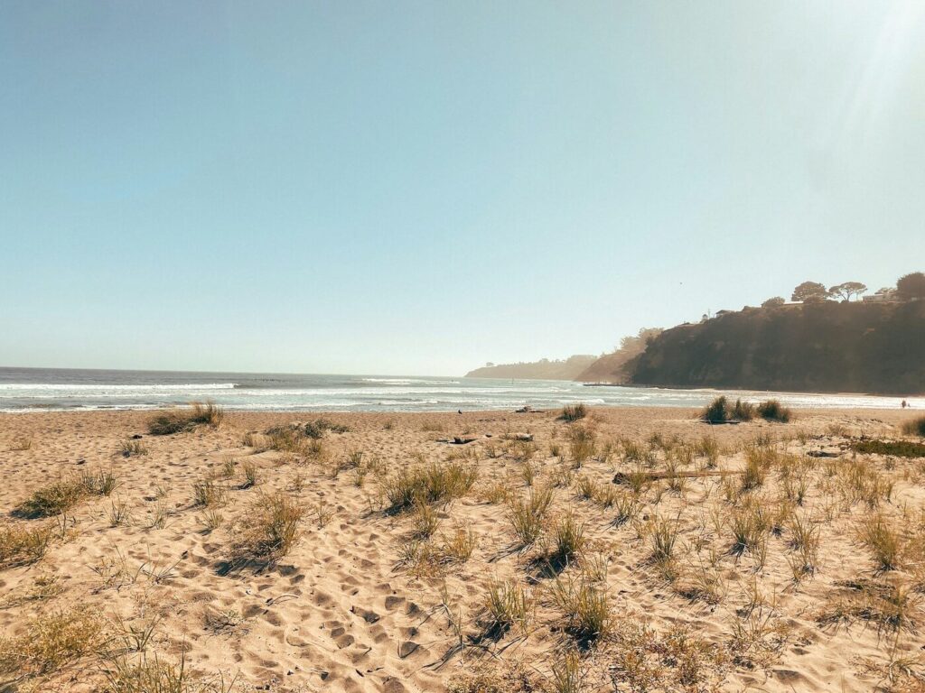 Stinson Beach on a clear sunny day in Marin County, California, with soft sand and ocean waves in the distance.