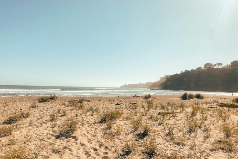Stinson Beach on a clear sunny day in Marin County, California, with soft sand and ocean waves in the distance.